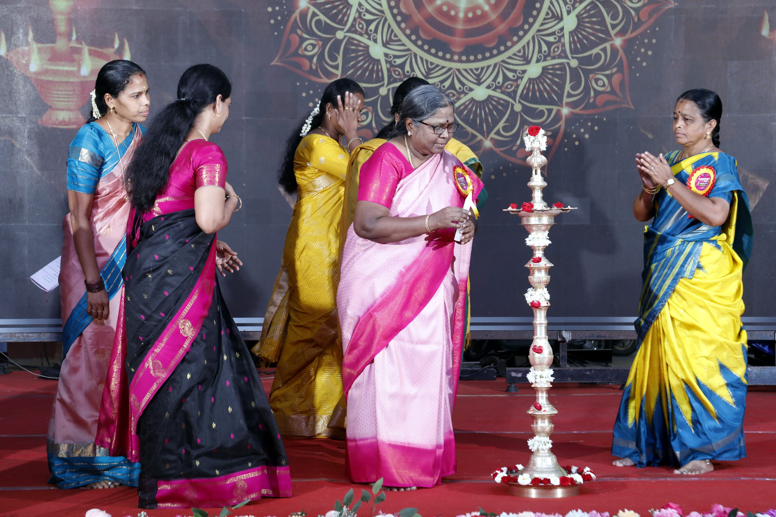 Guests lighting a ceremonial lamp on stage