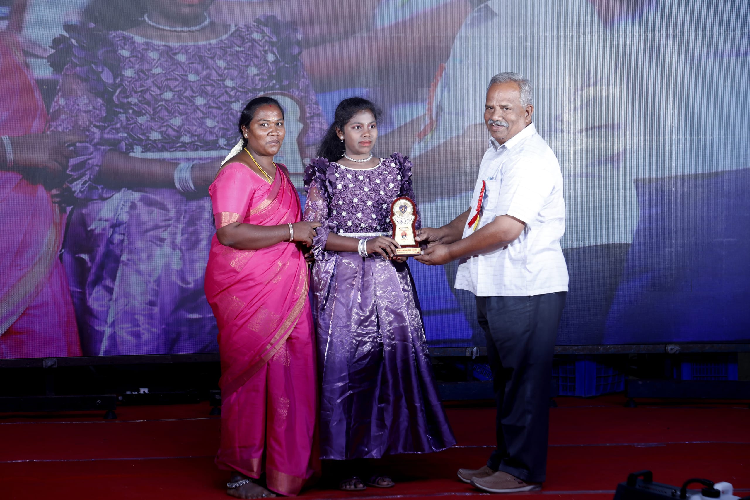 Girl receiving a trophy during the annual day awards