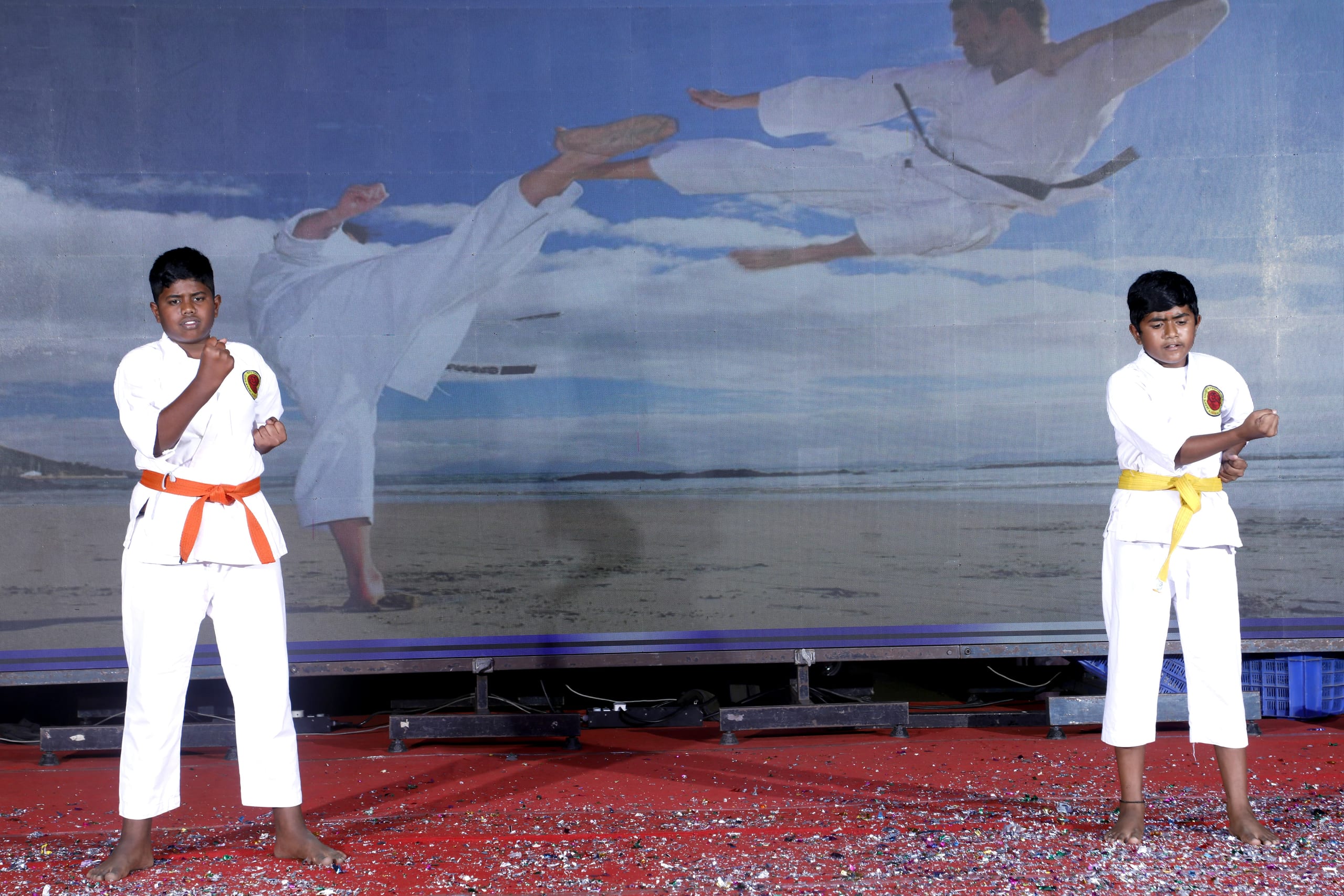 Student in white martial arts uniform performing on stage