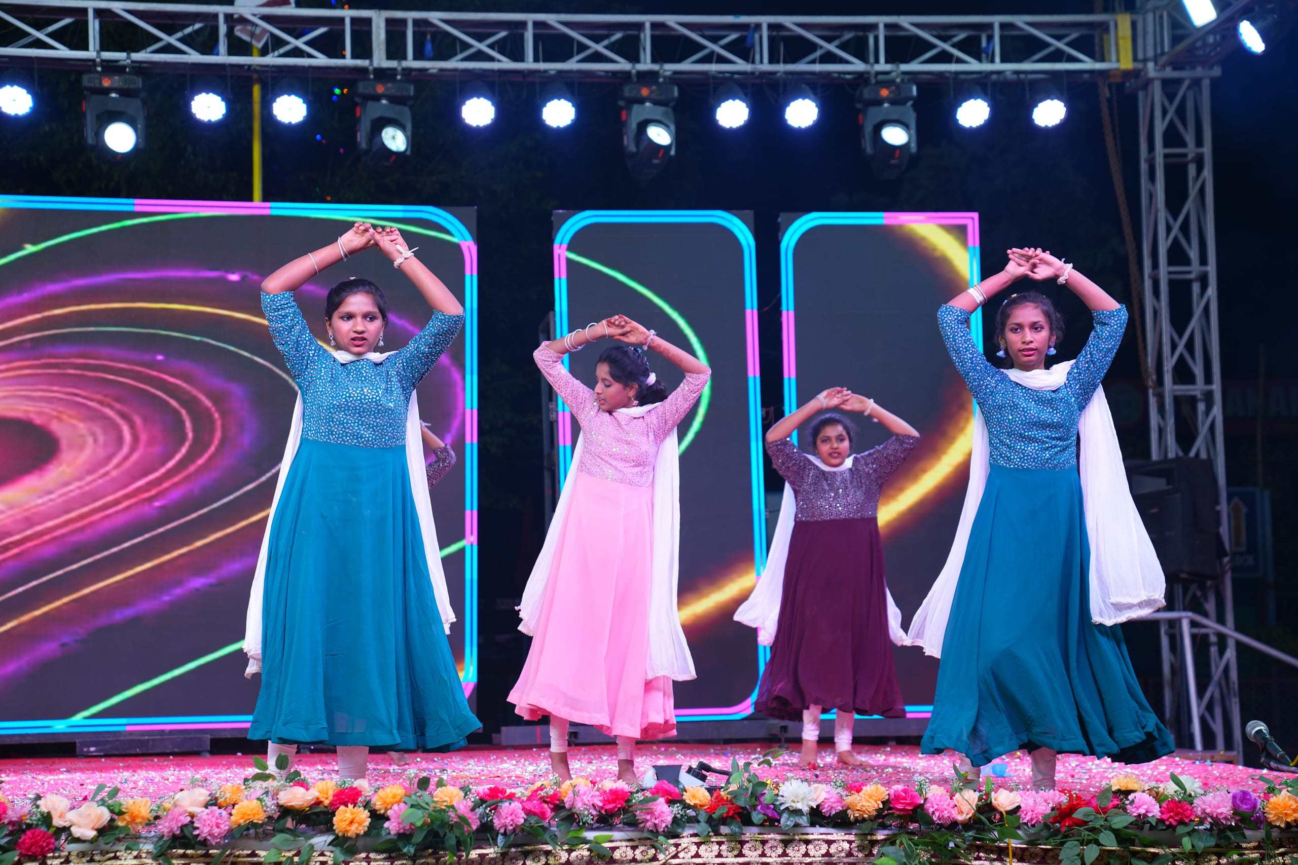 Students in colorful costumes performing a group dance