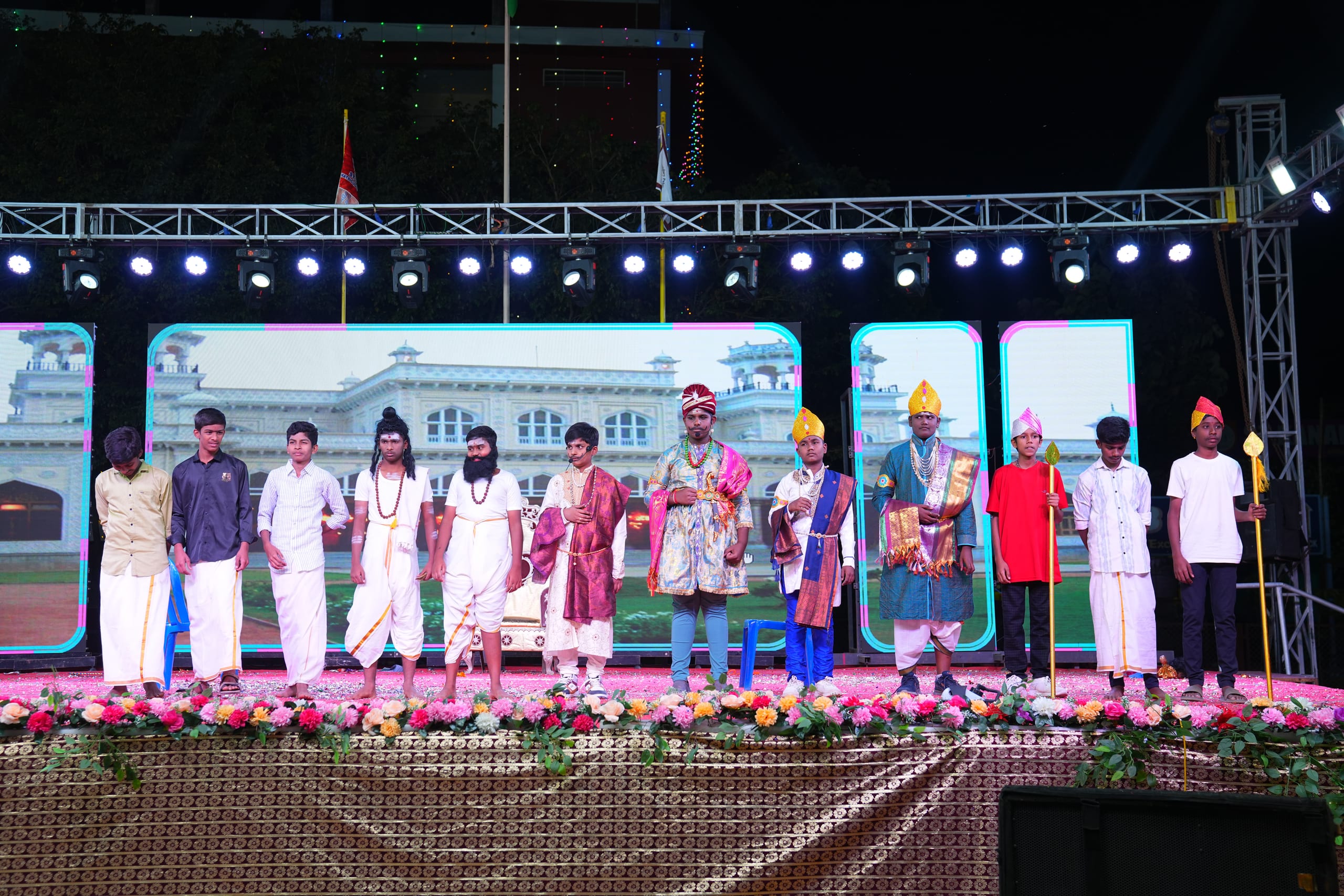Students in costume standing across the stage